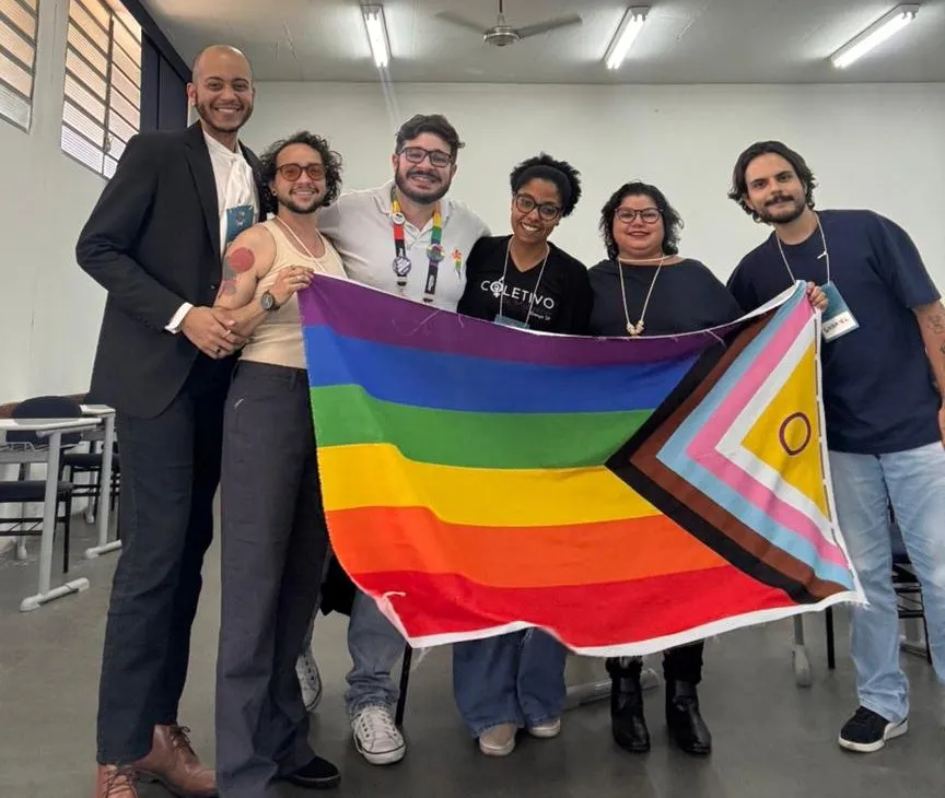 Gabriel Meyer com um grupo segurando a bandeira do Orgulho Progressista