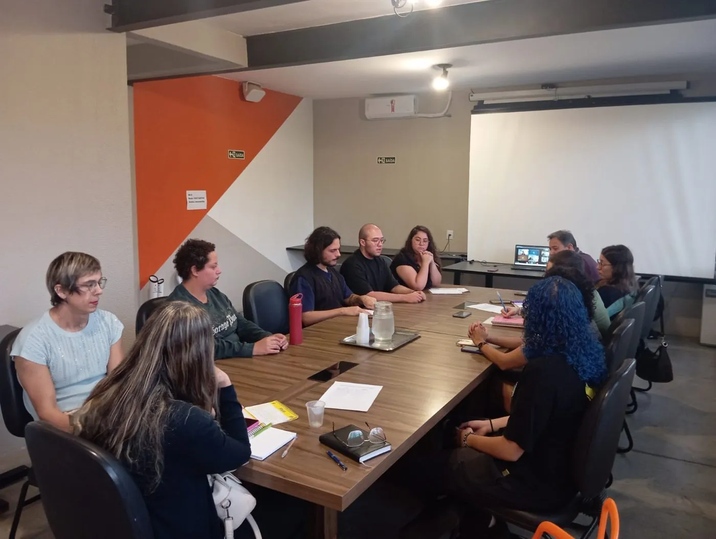 Pessoas reunidas ao redor de uma mesa de reunião, com Gabriel Meyer entre elas